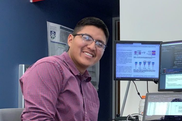 Portrait of Taylor Begaye smiling in front of computer